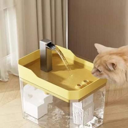 Gul vannfontene til katt vist med katt i bruk. Drikkefontene katt 1,5L som gir friskt vann og øker væskeinntaket.